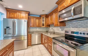 Wood cabinets, Granite counters, tiled backsplash, SS appliances