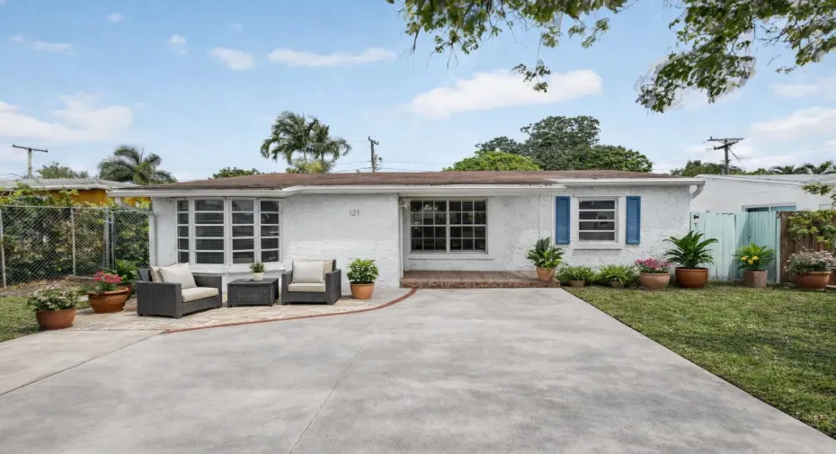 Front virtually staged with potted plants and seating