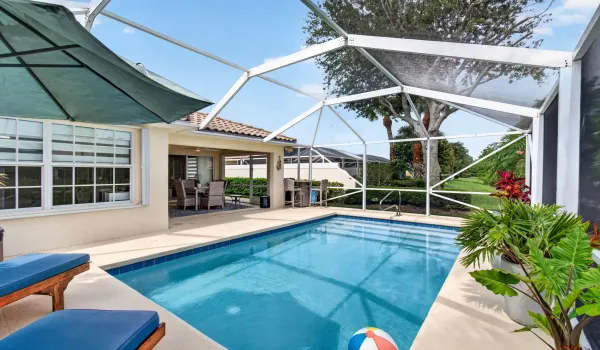 Screen enclosed pool with additional spacious covered patio.
