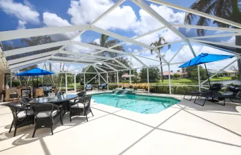 Pool, waterfall, huge deck area, summer kitchen & a full lake view beyond the rear of pool.