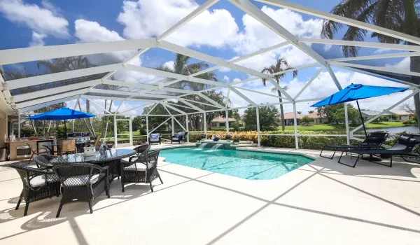 Pool, waterfall, huge deck area, summer kitchen & a full lake view beyond the rear of pool.