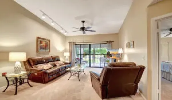 Sliding doors to screened balcony with view of lake and landscape.