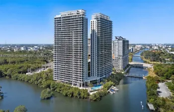 Striking twin-tower waterfront development surrounded by lush mangroves and shimmering bay waters, offering a sophisticated urban retreat with resort-style amenities.