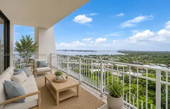 DIGITALLY STAGED BALCONY WITH VIEWS OF MIAMI WATERWAY AND LUSH GREEN SPACE.