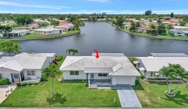 Aerial — home positioned on lake with community context