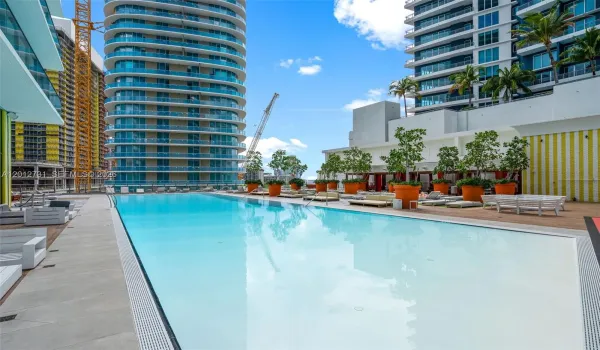 Resort-style pool with cabanas and signature SLS striped accents at SLS Brickell Dua.