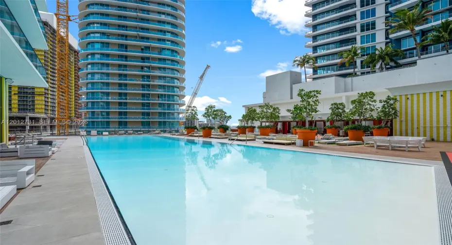 Rooftop pool with signature red-striped chaise lounges - elevated relaxation at SLS Brickell Dua.