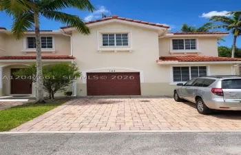 Street-facing attached one-car garage with private driveway and additional assigned parking.