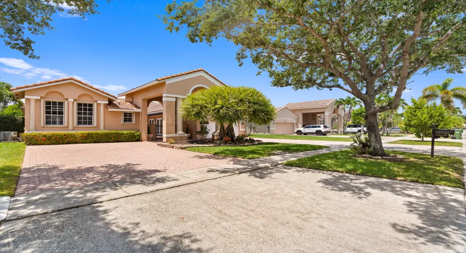 Beautifully positioned on an oversized waterfront lot, this impressive residence showcases timeless architecture, a grand covered portico and a spacious paver driveway that easily accommodates 9 cars plus a 2 car garage.