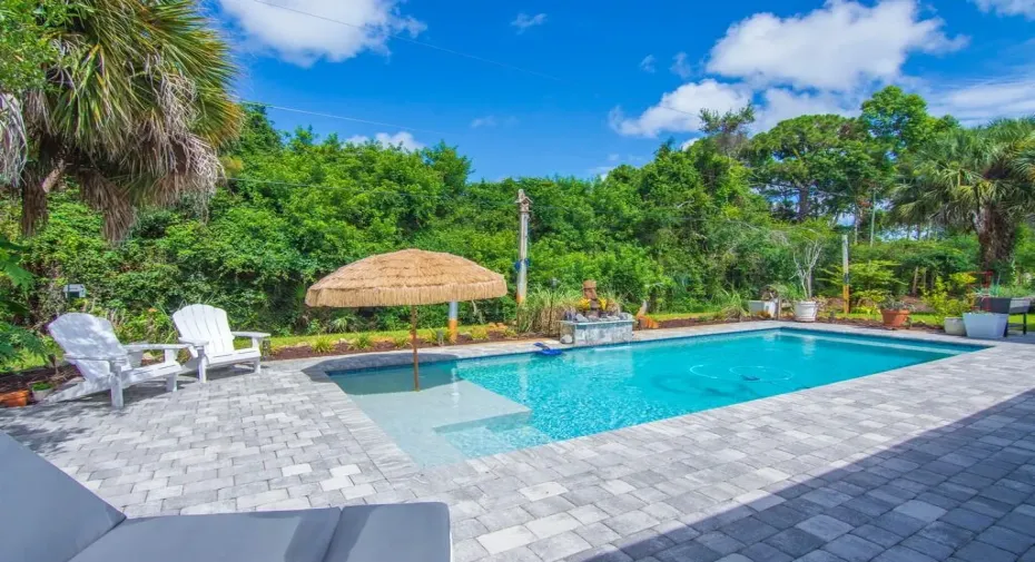 12x32 Saltwater pool with waterfall, sun shelf, and tiki umbrella