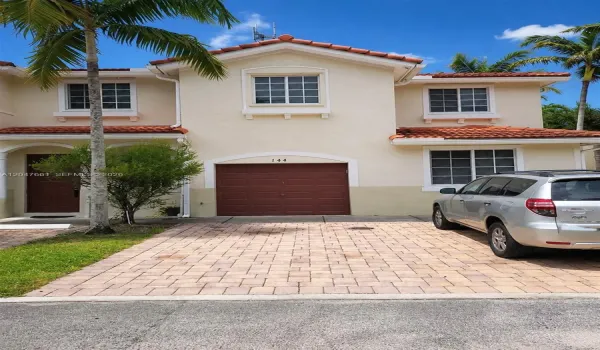 Street-facing attached one-car garage with private driveway and additional assigned parking.