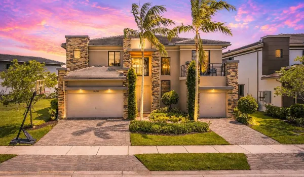Modern home at sunset with palm trees