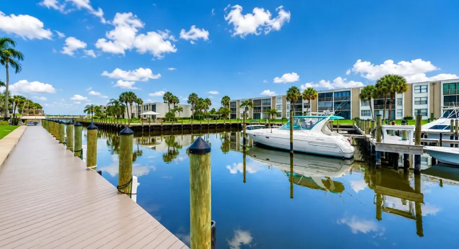 Waterfront property featuring a private boat dock, navigable canal access, direct water frontage, and mature palm landscaping