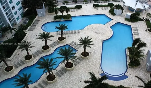 Amazing pool area with several spaces to entertain; daybeds, chairs, tiki bar, spa, gym, game room.