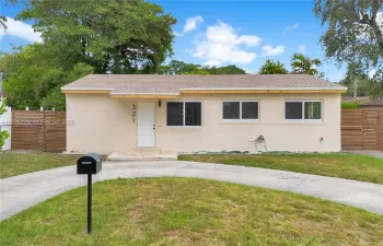 Front of Structure – Front view showcasing the home's new roof, updated windows, modern wood privacy fencing, and spacious front yard.