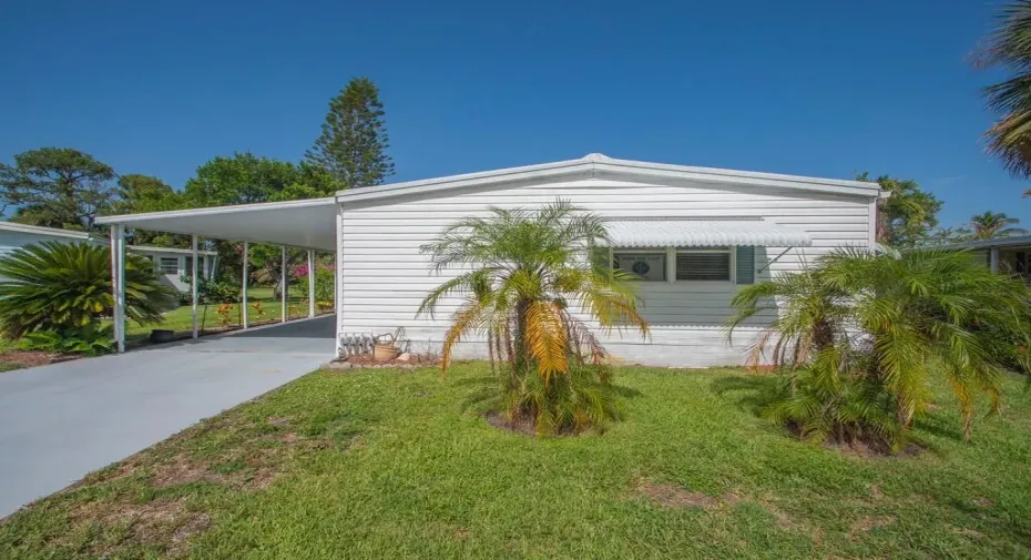 White horizontal siding exterior with a covered carport