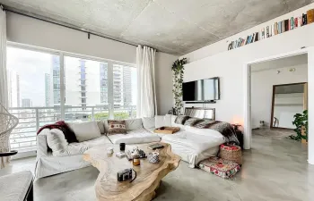 Floor-to-ceiling windows featuring city and water views, exposed concrete ceiling, and polished concrete flooring
