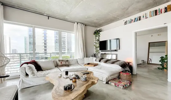 Floor-to-ceiling windows featuring city and water views, exposed concrete ceiling, and polished concrete flooring