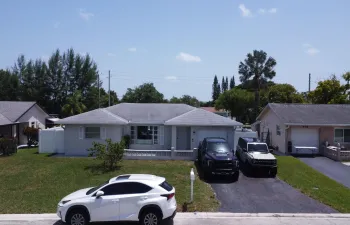 Single-story property featuring a light-colored stucco exterior and a gray shingle roof