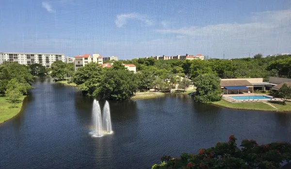 Expansive water feature with a dual-stream fountain and pool/clubhouse view.