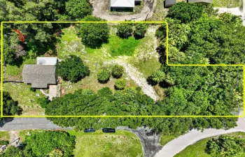Aerial perspective showcasing a parcel with established trees and a residential structure