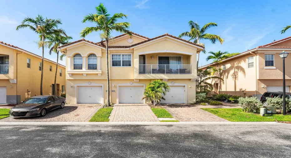 Mediterranean-style facade featuring a tile roof, stucco exterior, and arched windows