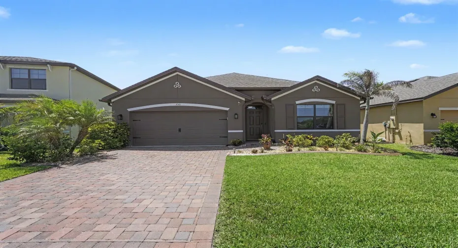 Contemporary stucco exterior with a multi-toned paver driveway