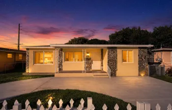 Ranch-style residence featuring a stone veneer facade and light stucco exterior