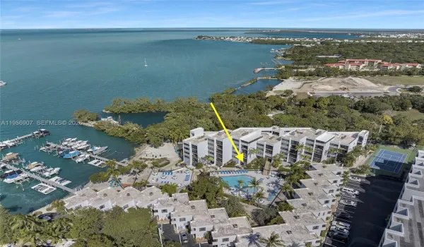 Aerial view of the waterfront community set along the bay with marina access and open water beyond