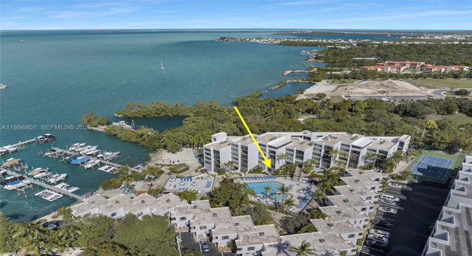 Aerial view of the waterfront community set along the bay with marina access and open water beyond