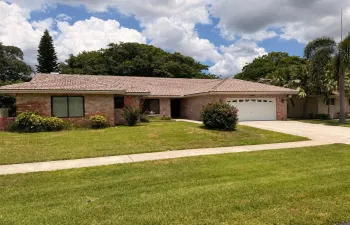 Brick-clad exterior with a tile roof and a two-car garage