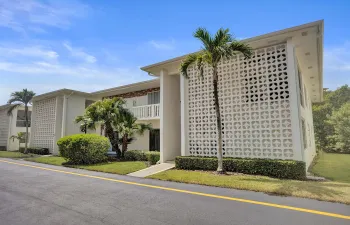 Mid-century modern building featuring decorative concrete block screen walls, white exterior finish, and a flat roofline