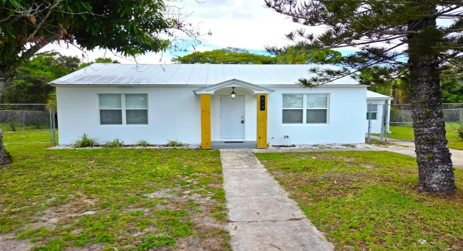 White exterior residence featuring a metal roof and a covered entryway