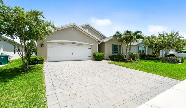 Built in 2021, this beautifully upgraded DR Horton Neuville model offers a desirable triple-split floor plan on an oversized lot. The CBS stucco home features impact-resistant windows and doors, decorative shutters, a two-car garage with a paver driveway, and mature tropical landscaping for exceptional curb appeal. Inside, wood-look tile flooring flows throughout the home, complemented by quartz countertops, upgraded wood-look cabinetry, a spacious pantry, and upgraded ceiling fans. Step outside to your private backyard retreat featuring a heated saltwater pool and a custom screened enclosure with panoramic picture-window screening—perfect for relaxing or entertaining year-round.