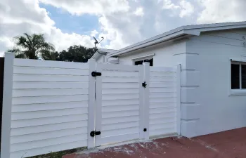 White horizontal slat fencing with a gate, featuring black hardware