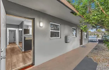Exterior entryway featuring a concrete walkway, mailboxes, and a dark wood-finish entry door