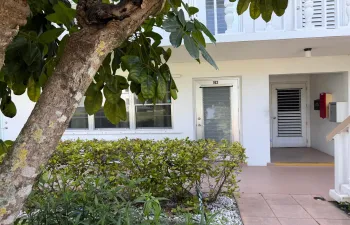 Front door facing patio area with grill and garden view.