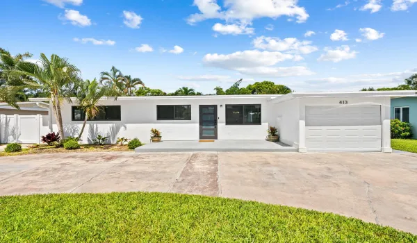 Modern white exterior with dark-framed windows, a sleek entry door, and a white garage door