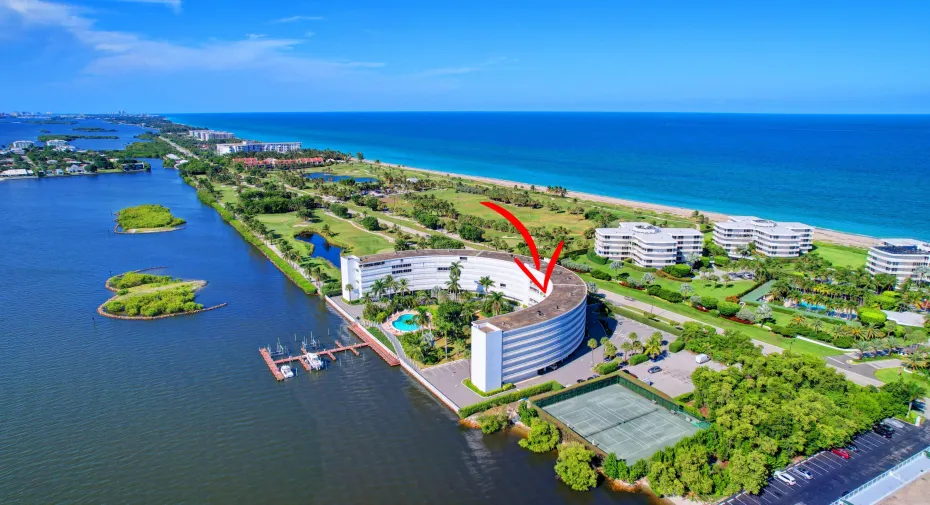 Curved architectural building with waterfront access and a private marina