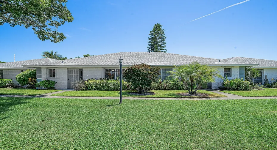 White brick exterior with a grey shingle roof