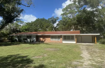 Single-story residence featuring a rustic red metal roof and a partial brick facade