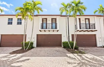 White stucco exterior with brown garage doors and coordinating trim