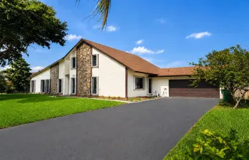 Spacious residence featuring a stucco exterior with stone accents, a brown shingle roof, an attached garage