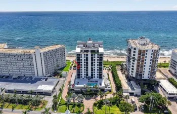 Oceanfront mid-rise building featuring a modern facade, private balconies, and an outdoor swimming pool