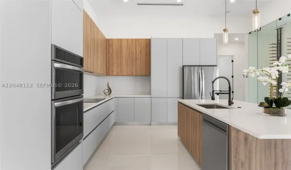 The EXPANSIVE ISLAND offers FLEXIBLE SEATING for CASUAL DINING or FORMAL GATHERINGS, and a FULL QUARTZ BACKSPLASH adds MODERN SOPHISTICATION