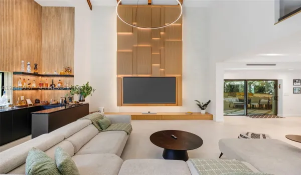 The heart of the home, with soaring two-story ceilings, dramatic architectural volume, and a custom feature wall creates an unforgettable first impression
