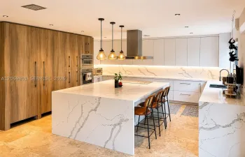 A true showpiece, this custom chef's kitchen was designed with no expense spared. Highlights include top-of-the-line Thermador appliances, separate full-size Miele refrigerator and freezer units, a spectacular oversized waterfall island that comfortably seats six, extensive custom cabinetry with abundant storage, quartz countertops and full-height backsplash, designer pendant lighting, and expansive prep space. Beautifully designed for both serious cooking & effortless entertaining, centerpiece of the home