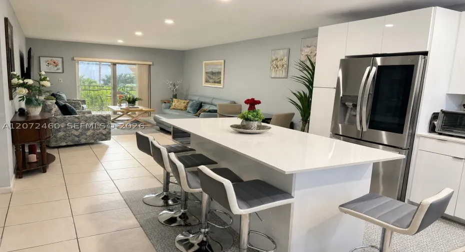 Modern Open-Concept Kitchen & Living Area
Bright open-concept layout featuring a large kitchen island, modern cabinetry, stainless-steel appliances, and direct access to the private balcony.