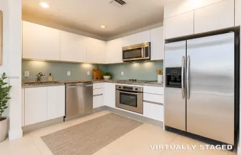 Virtually StaVirtually staged elements: area rug, decorative plant, countertop plants, cutting boards, utensil holder, soap dispenser, and other decorative kitchen accessories.ged -