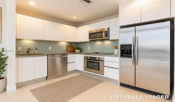 Virtually StaVirtually staged elements: area rug, decorative plant, countertop plants, cutting boards, utensil holder, soap dispenser, and other decorative kitchen accessories.ged -